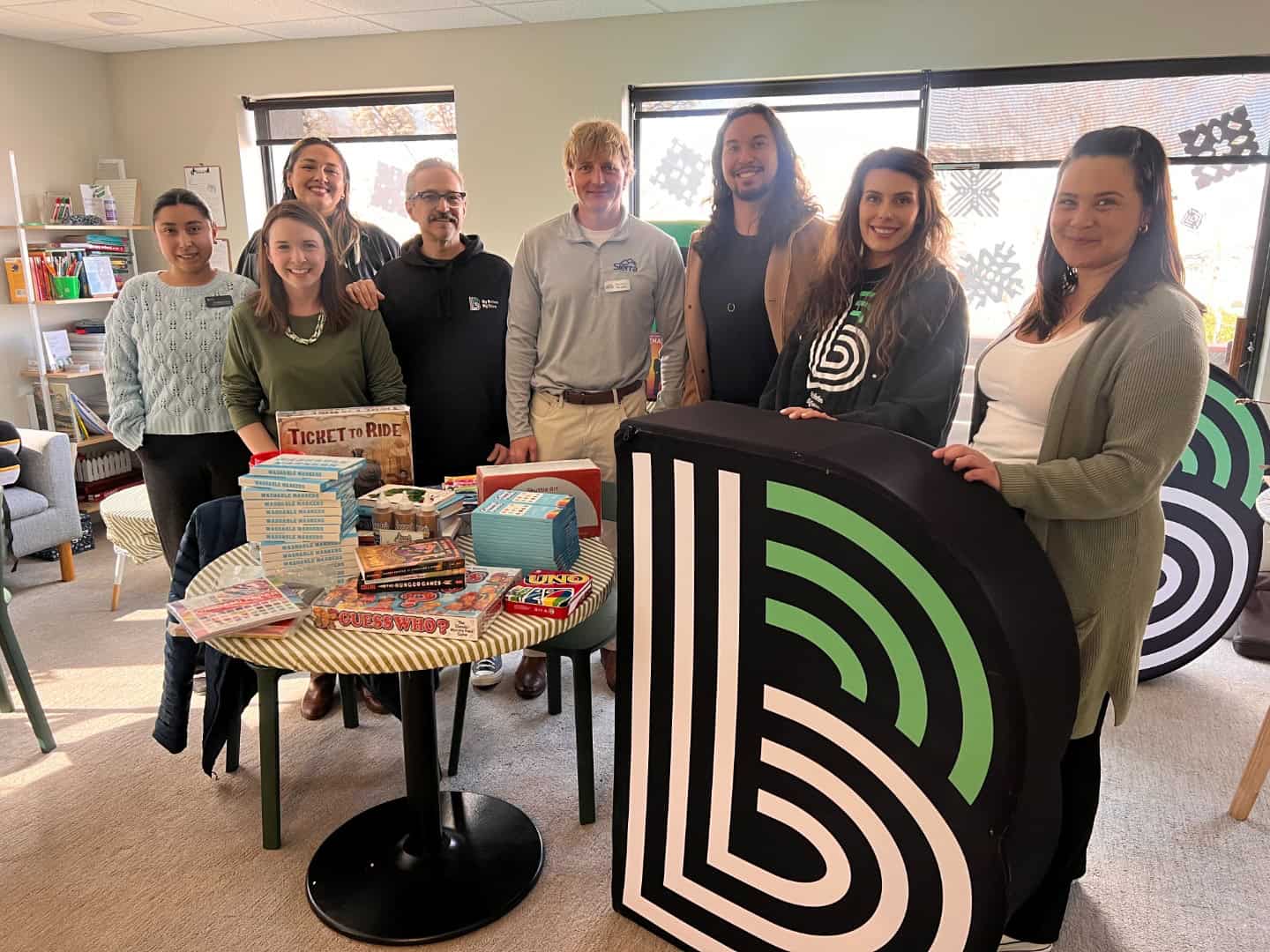 The Sierra Homebuyers team and Big Brothers Big Sisters staff with a table of donated games and books