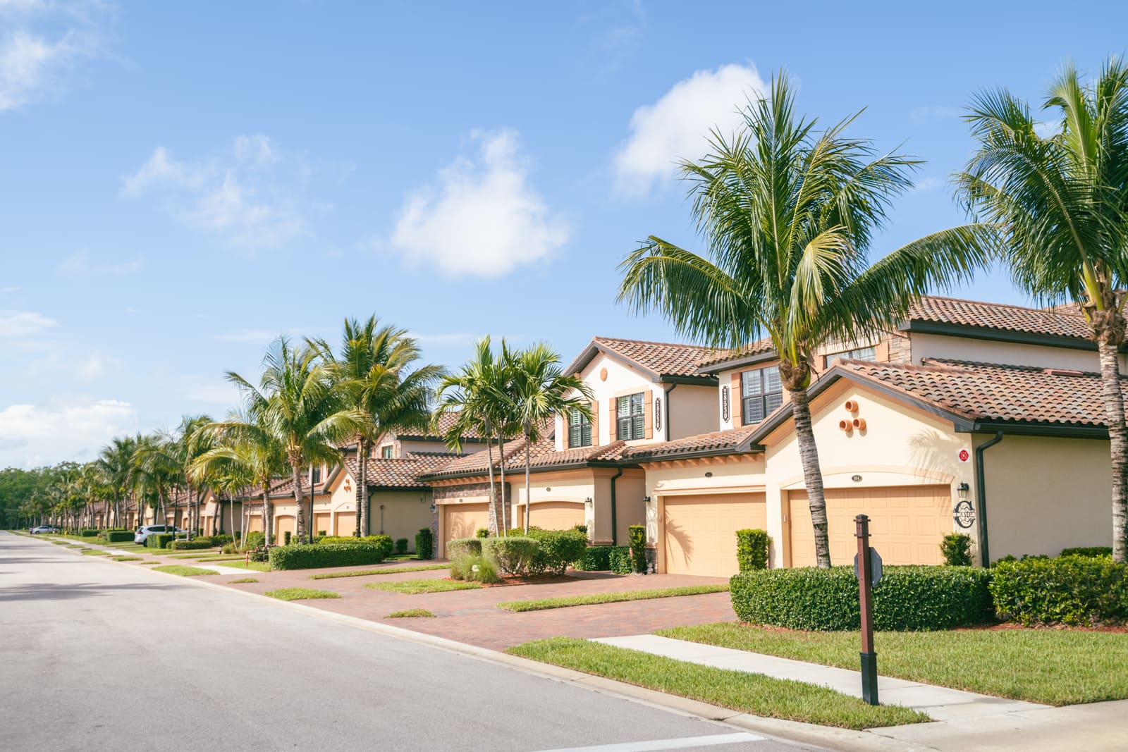 A Southwest Florida street of tile-roof homes and palms